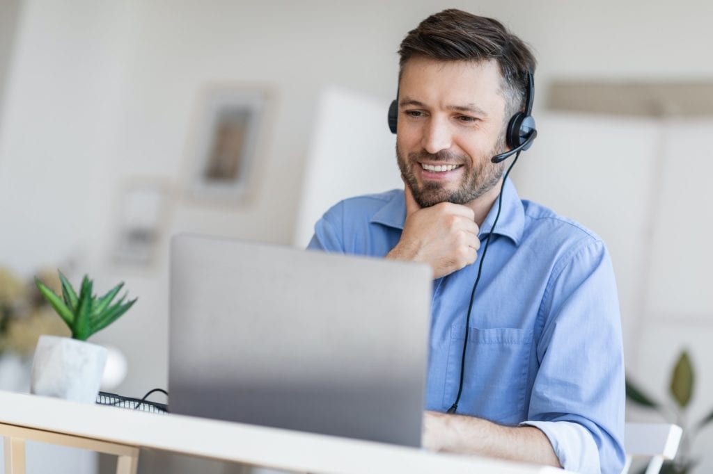Hotline Support Service. Male call center operator in headset working with laptop