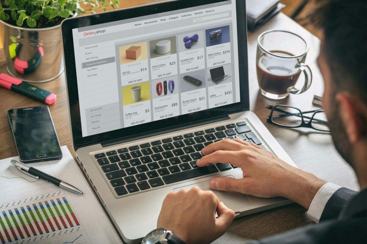 Tiendas Online 2 Online shop website developer working with a laptop, office desk background.
