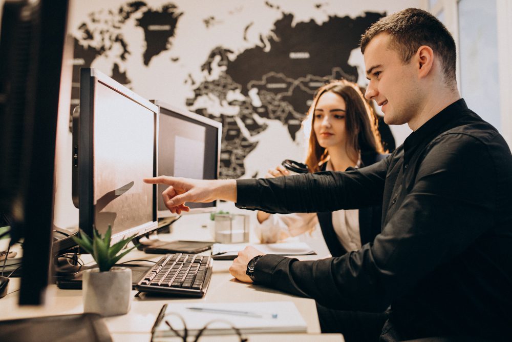 workers at an it company working on computer | CentOS vs CloudLinux: ¿Cuál elegir?