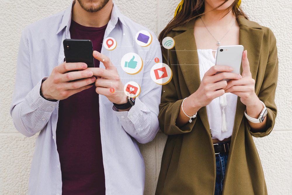 ¿Cuáles son los Beneficios de las campañas de marketing en redes sociales? 2 mobile notification icons man woman using cell phone | ¿Cuáles son los Beneficios de las campañas de marketing en redes sociales?